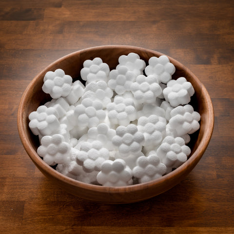Flower-shaped toilet cleaning pods in a wooden bowl